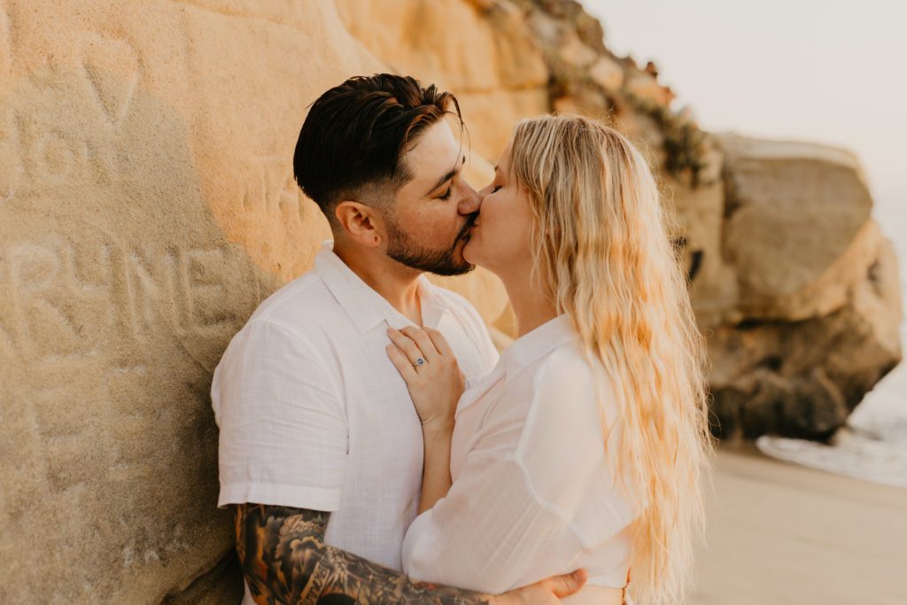 Couple kissing in San Diego after getting engaged.