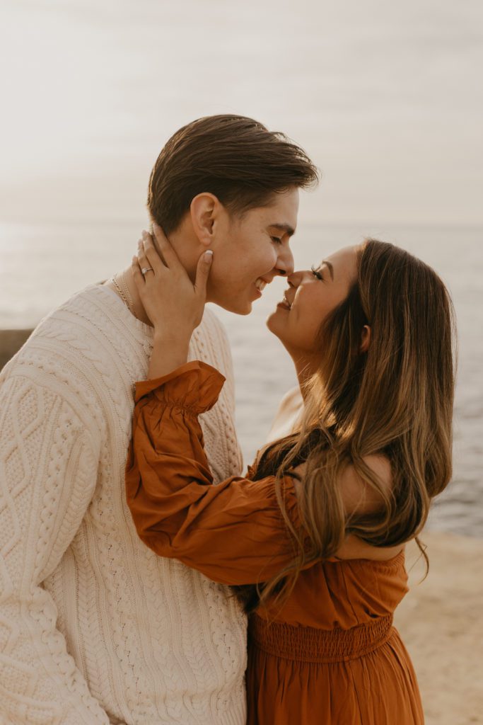 Couple leaning in for a kiss at Sunset Cliffs