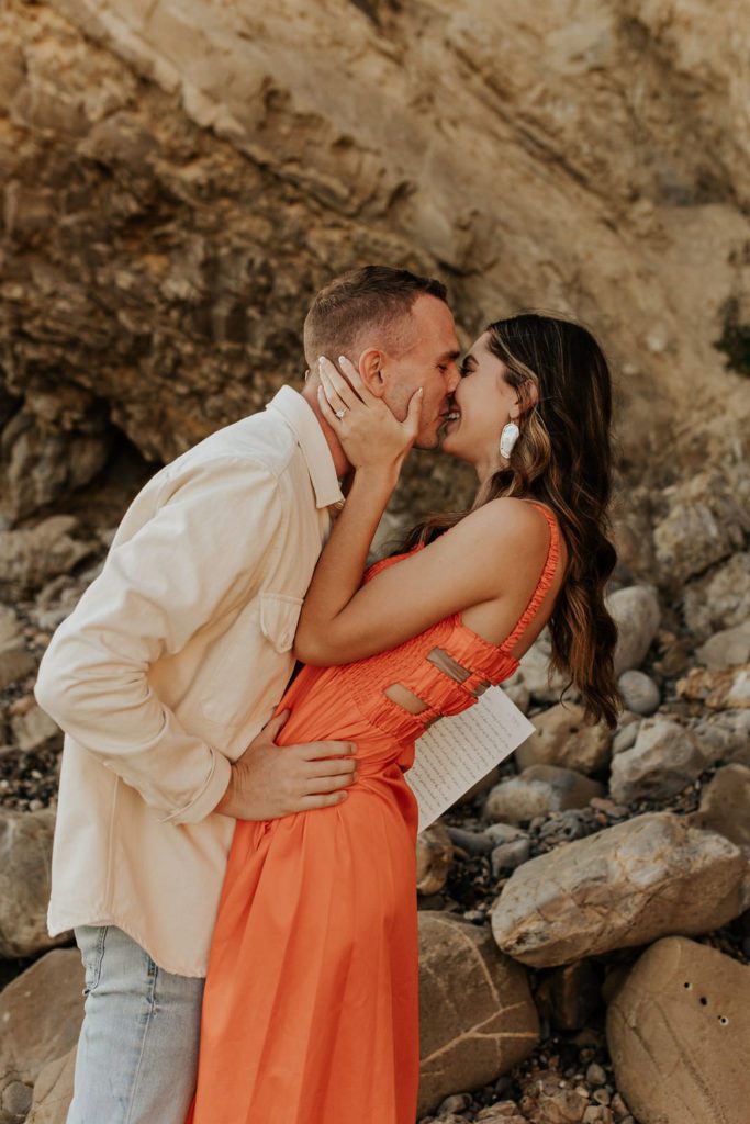 Engaged couple kissing at Little Corona Del Mar