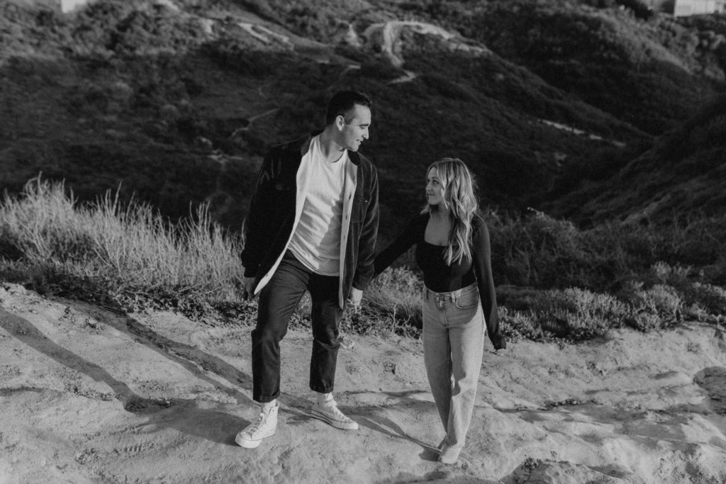 Black and white image of a couple walking together.